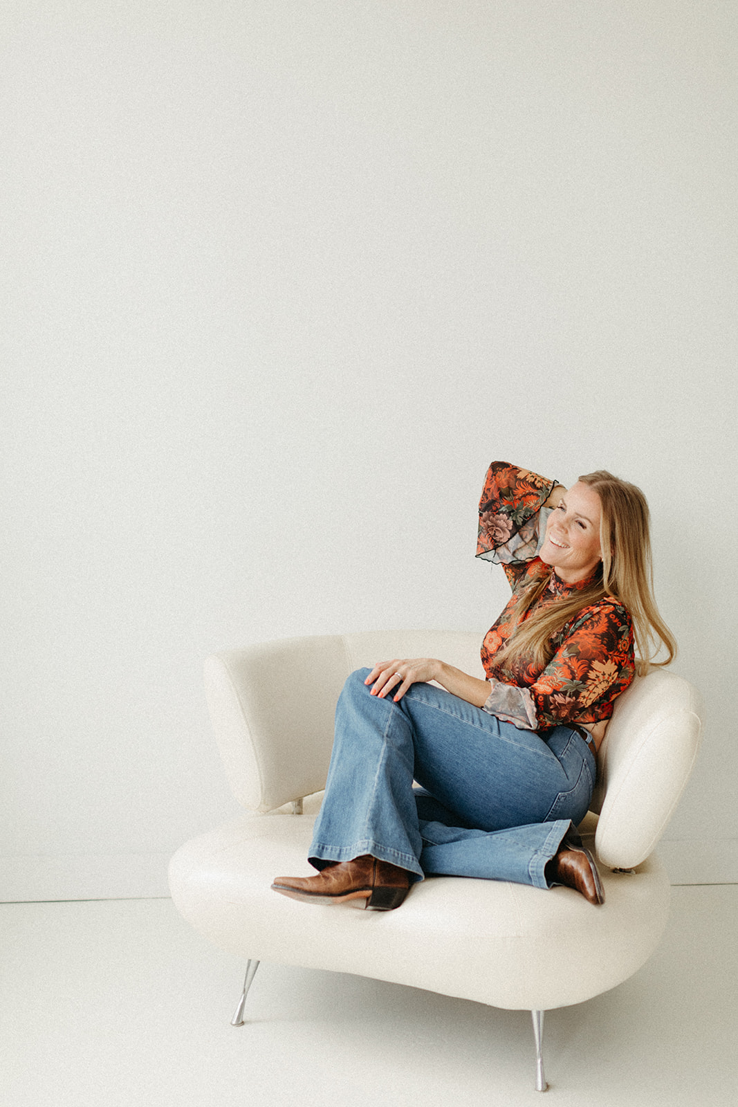 Wedding officiant in clarington Ontario Jennifer van Son sitting in a chair in a white studio